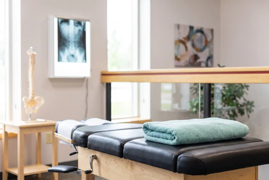 Chiropractic adjustment table, spine model and spine X-ray on a light box in the Westminster office