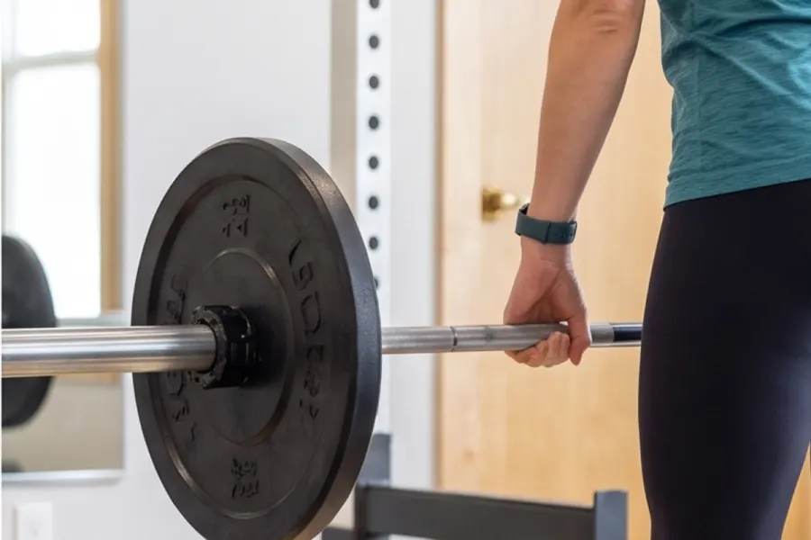 Athlete racking a loaded barbell in a bright gym